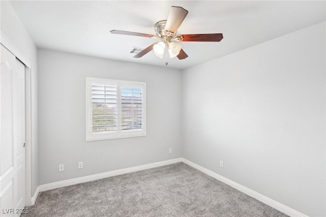 carpeted spare room with ceiling fan