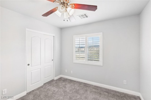 unfurnished bedroom with ceiling fan, a closet, and light colored carpet