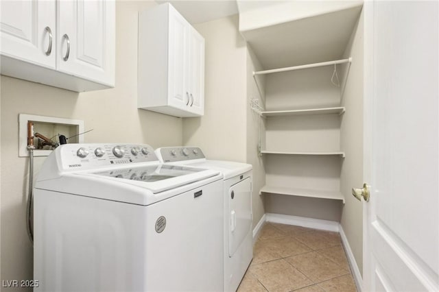 washroom featuring cabinets, independent washer and dryer, and light tile patterned flooring