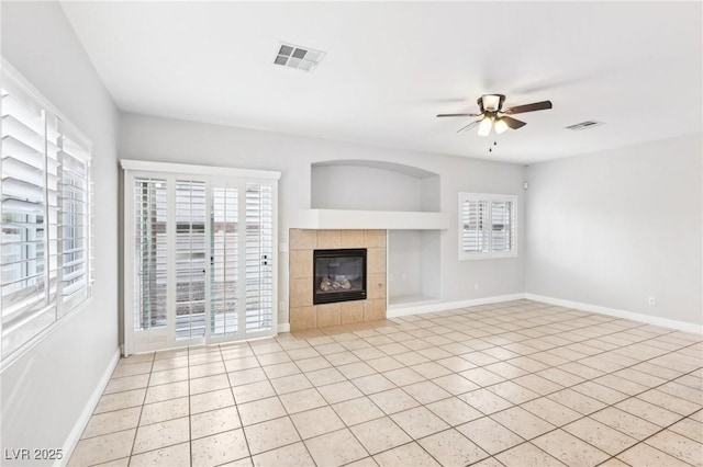 unfurnished living room featuring a tile fireplace, ceiling fan, and light tile patterned floors