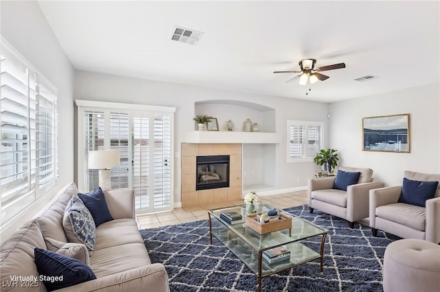 living room with a fireplace, tile patterned floors, and ceiling fan