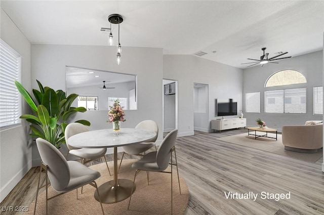 dining area with light wood-type flooring, ceiling fan, lofted ceiling, and plenty of natural light