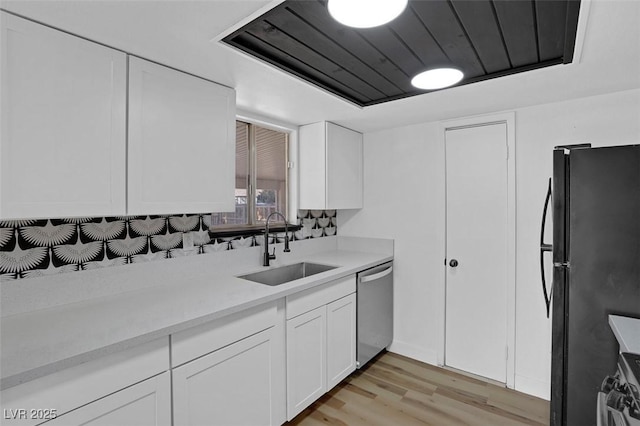 kitchen featuring sink, stainless steel appliances, ventilation hood, white cabinets, and light wood-type flooring