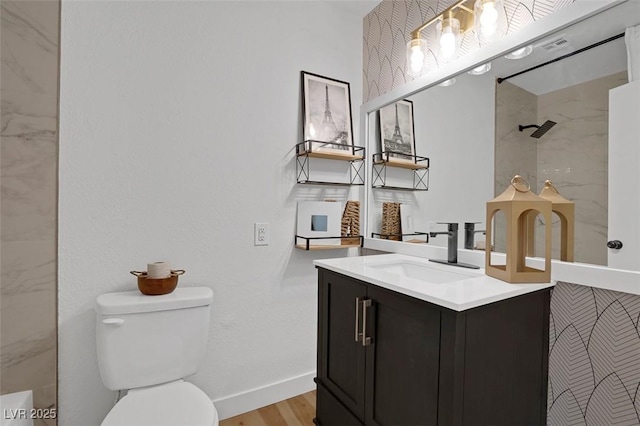 bathroom featuring vanity, wood-type flooring, and toilet