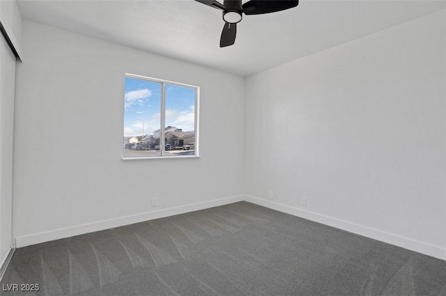 spare room featuring ceiling fan and dark colored carpet