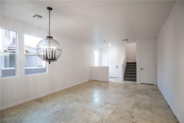 spare room with a chandelier