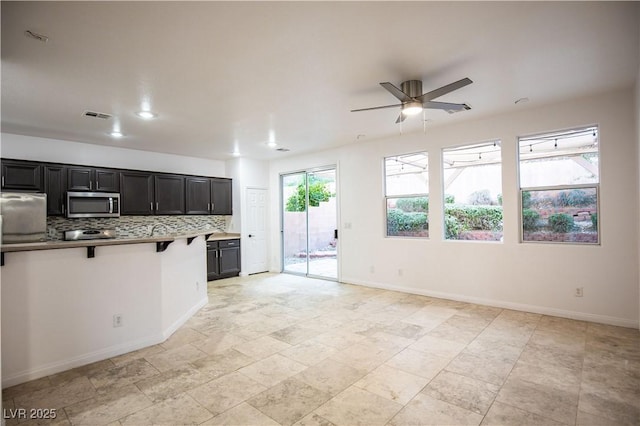 kitchen with decorative backsplash, refrigerator, and ceiling fan