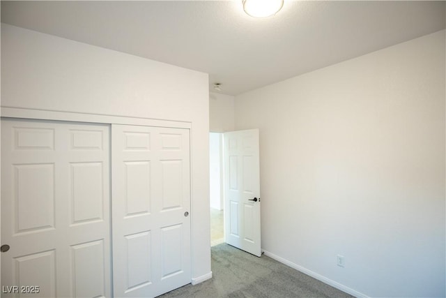 unfurnished bedroom with light carpet and a closet