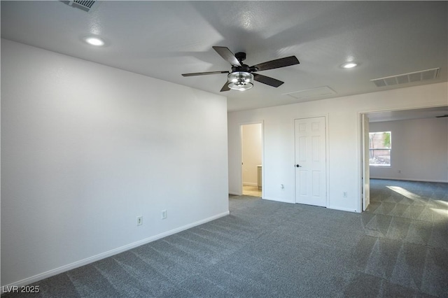 spare room with dark carpet and ceiling fan