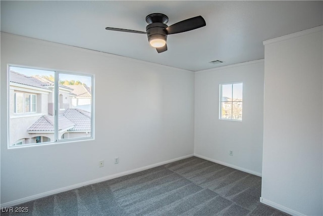 carpeted spare room with plenty of natural light, crown molding, and ceiling fan