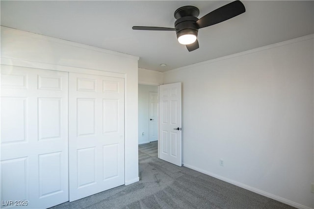 unfurnished bedroom with ceiling fan, a closet, carpet floors, and ornamental molding