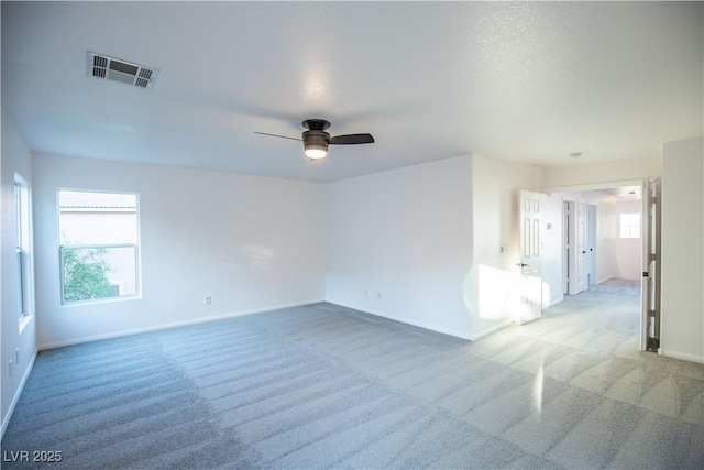 carpeted spare room featuring ceiling fan and a textured ceiling