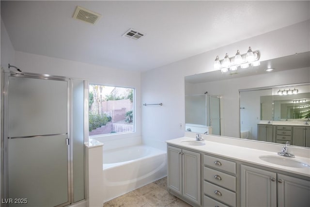 bathroom with vanity and shower with separate bathtub