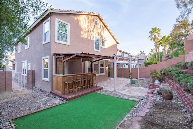 rear view of property with a patio area and a bar