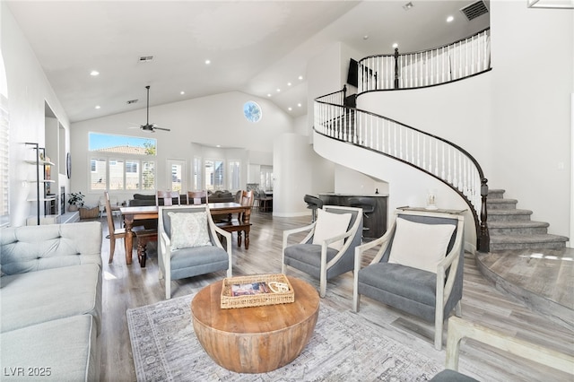 living room with ceiling fan, high vaulted ceiling, and light hardwood / wood-style flooring