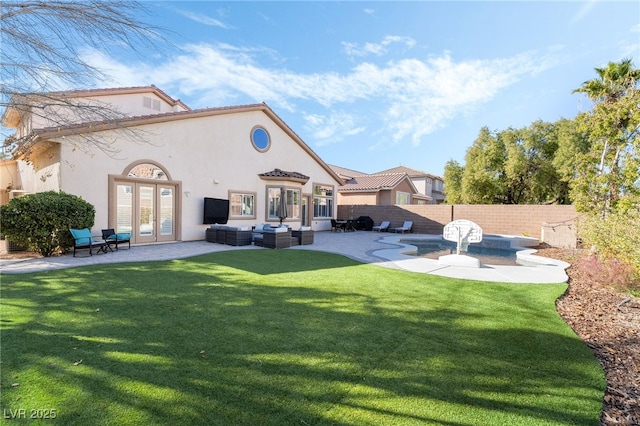 rear view of property with a lawn, a patio area, an outdoor hangout area, and french doors