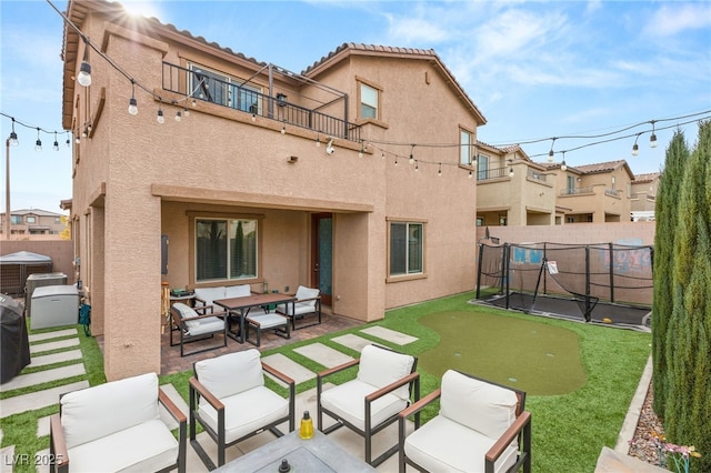 rear view of property featuring a patio and a balcony