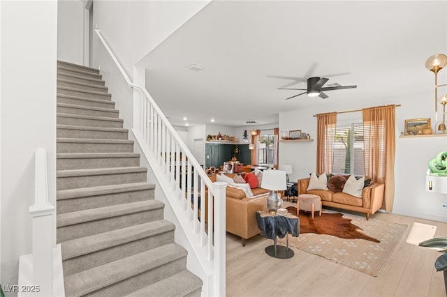 living room with ceiling fan and light hardwood / wood-style flooring