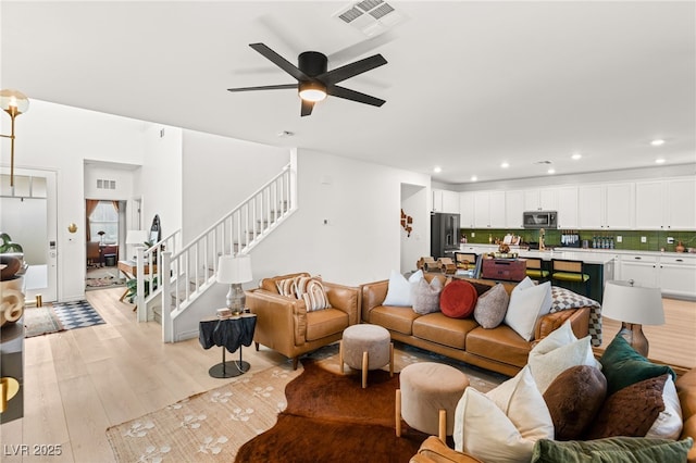 living room with ceiling fan and light wood-type flooring