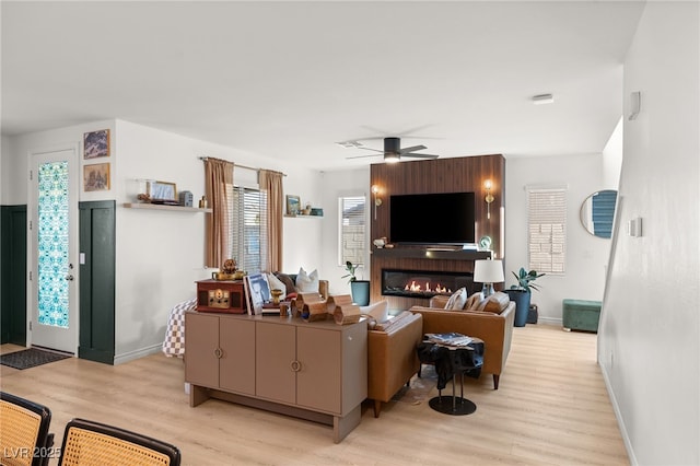 living room with light wood-type flooring and ceiling fan