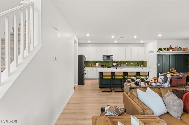 living room featuring light wood-type flooring and sink