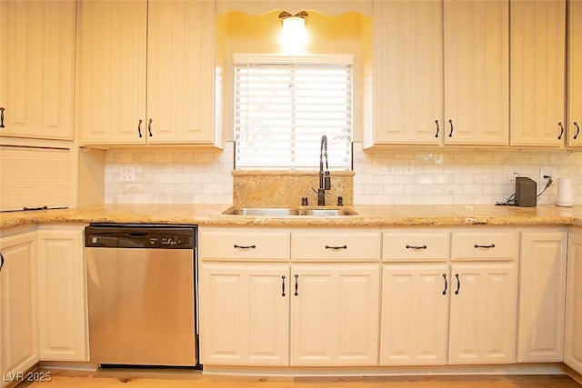 kitchen with light stone counters, sink, decorative backsplash, and dishwasher