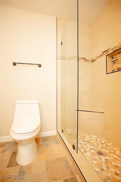 bathroom with toilet and tiled shower