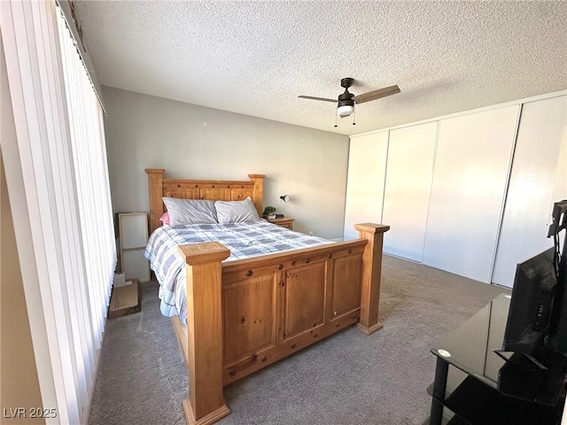 carpeted bedroom featuring ceiling fan and a textured ceiling