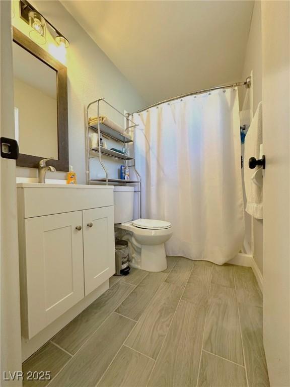 bathroom featuring vanity, toilet, and walk in shower