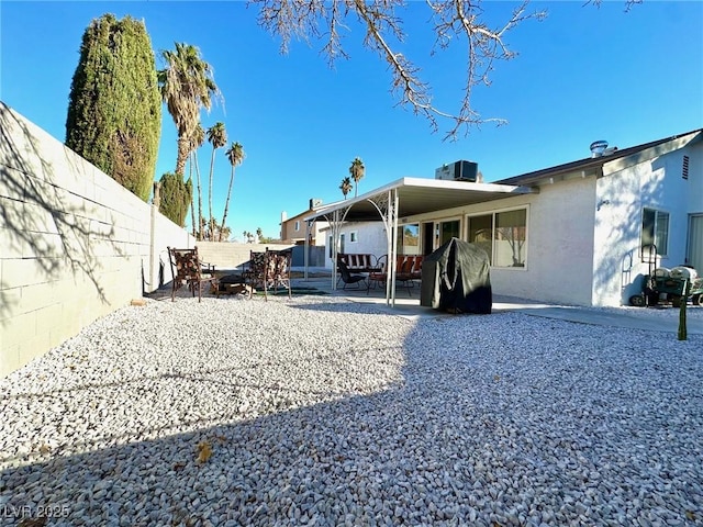 rear view of house with central AC and a patio