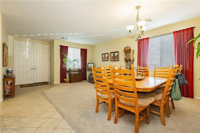 carpeted dining room featuring an inviting chandelier