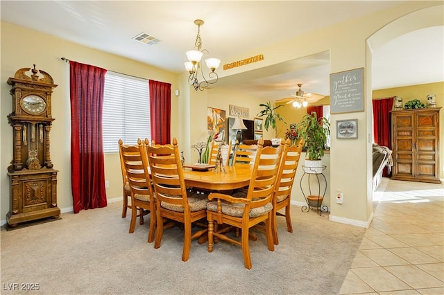 dining space featuring ceiling fan with notable chandelier and light colored carpet