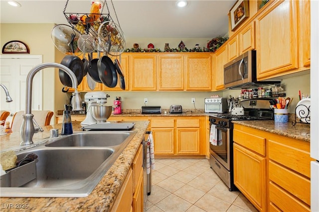 kitchen featuring light stone counters, light tile patterned flooring, sink, and stainless steel appliances