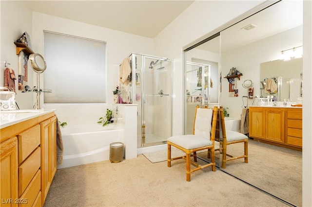 bathroom featuring vanity and shower with separate bathtub