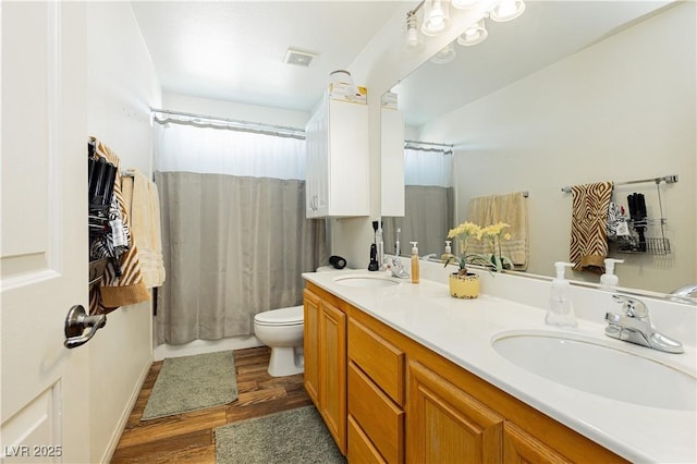 bathroom with hardwood / wood-style floors, vanity, and toilet