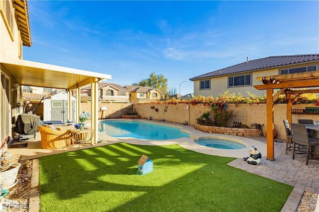 view of pool featuring an in ground hot tub, a yard, a patio, and a storage unit