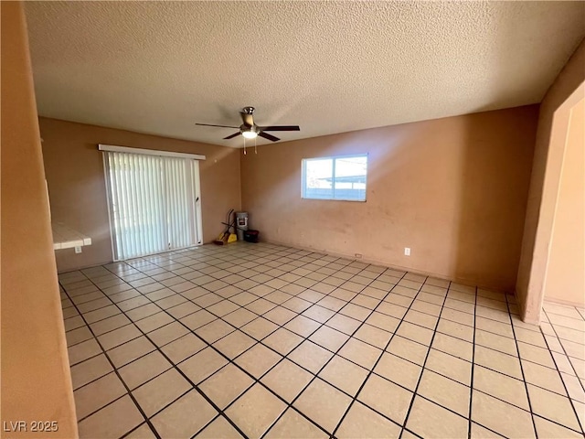 tiled spare room with a textured ceiling and ceiling fan