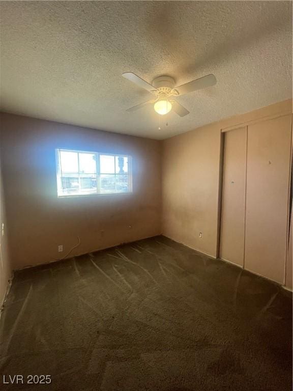 unfurnished bedroom with ceiling fan, a closet, carpet floors, and a textured ceiling