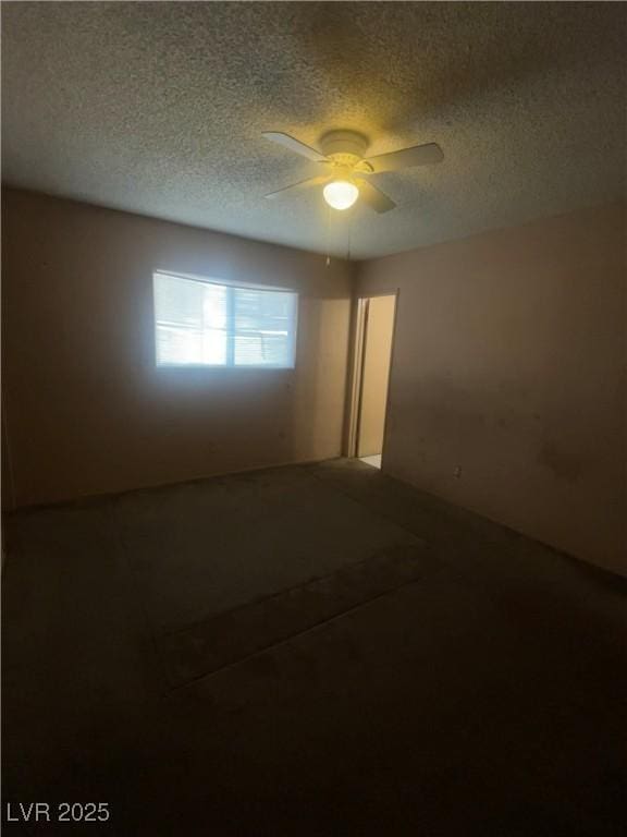 unfurnished room with ceiling fan and a textured ceiling