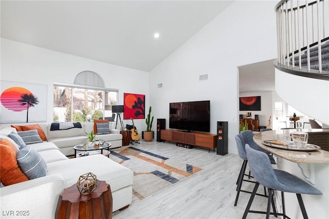 living room featuring light hardwood / wood-style flooring and high vaulted ceiling