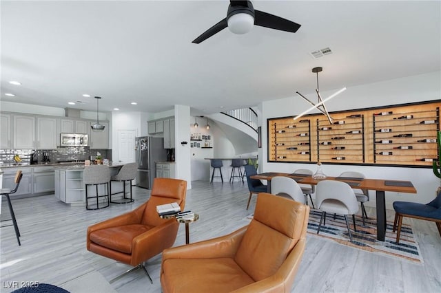 living room featuring ceiling fan and light hardwood / wood-style flooring