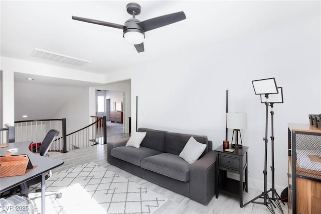 living room featuring ceiling fan and light hardwood / wood-style flooring