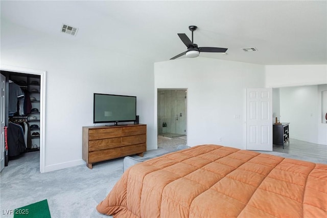 bedroom featuring light carpet, ceiling fan, a spacious closet, a closet, and lofted ceiling