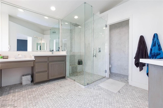 bathroom with tile patterned flooring, vanity, toilet, and a shower with door