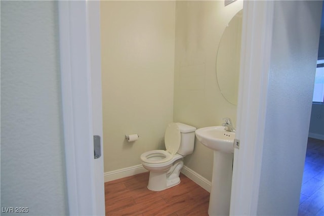 bathroom with hardwood / wood-style floors, toilet, and sink