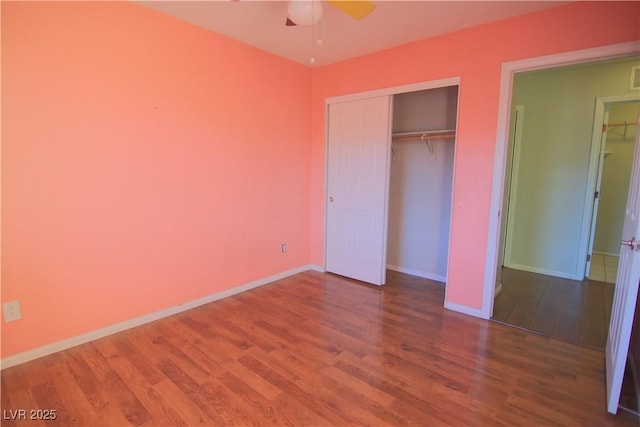 unfurnished bedroom with hardwood / wood-style flooring, a closet, and ceiling fan