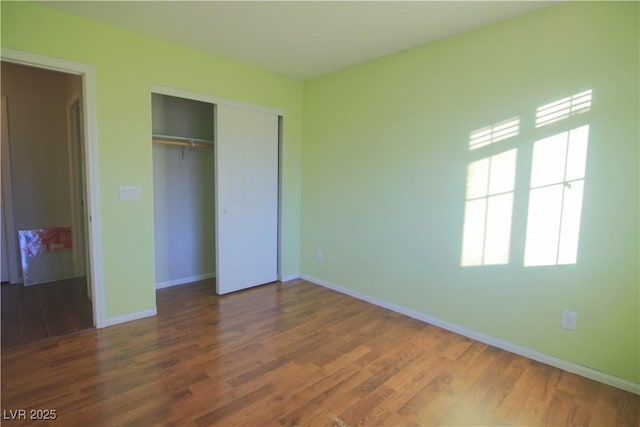 unfurnished bedroom with a closet and dark wood-type flooring