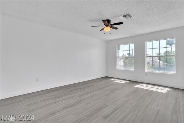 empty room featuring wood-type flooring, a textured ceiling, and ceiling fan