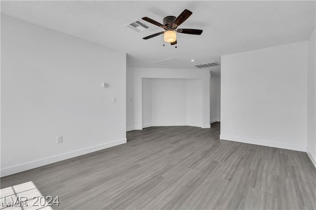 unfurnished room with hardwood / wood-style flooring, ceiling fan, and a textured ceiling