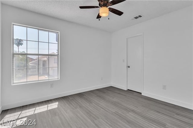 empty room with wood-type flooring, a textured ceiling, and ceiling fan